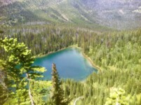 a blue lake in a valley surrounded by trees