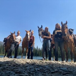 a group of people standing next to their horses