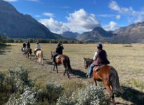 horse riders on a trail in mountain valley