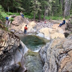 hikers hanging out by a creek